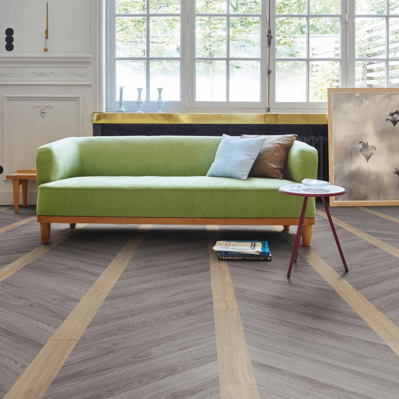 Moduleo - Luxus-Vinylboden - Chevron Geschichte - grünes Sofa auf einem Boden in Holzoptik Chevron Muster